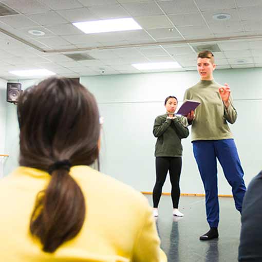 Photo of Laura Brigg giving a dance group instructions